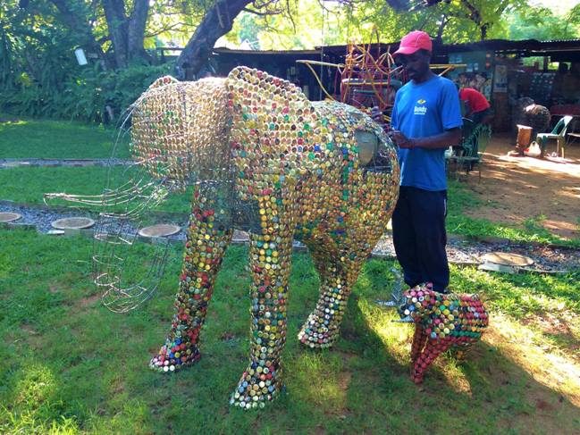 Artist in Victoria Falls constructing donation boxes from recycled material